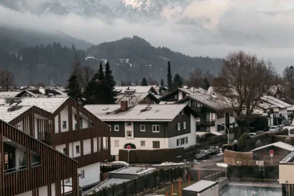 Zimmerausblick Eine Gruppe von Häusern vor schneebedeckten Bergen.