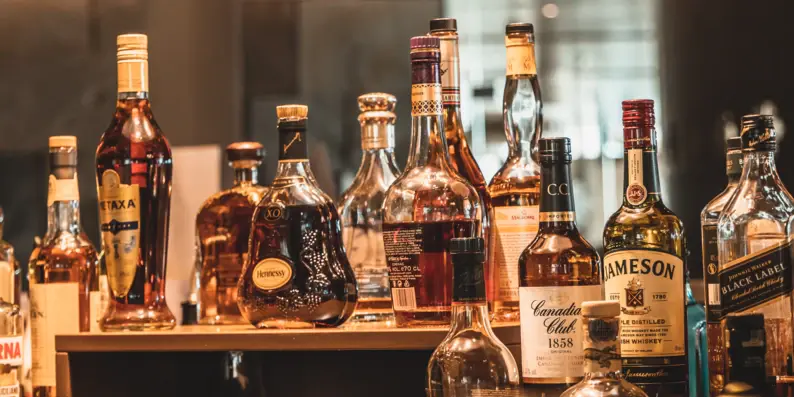 Eine Gruppe von Alkoholflaschen auf einem Tisch in einer Bar. Eine Gruppe von Alkoholflaschen auf einem Tisch in einer Bar.