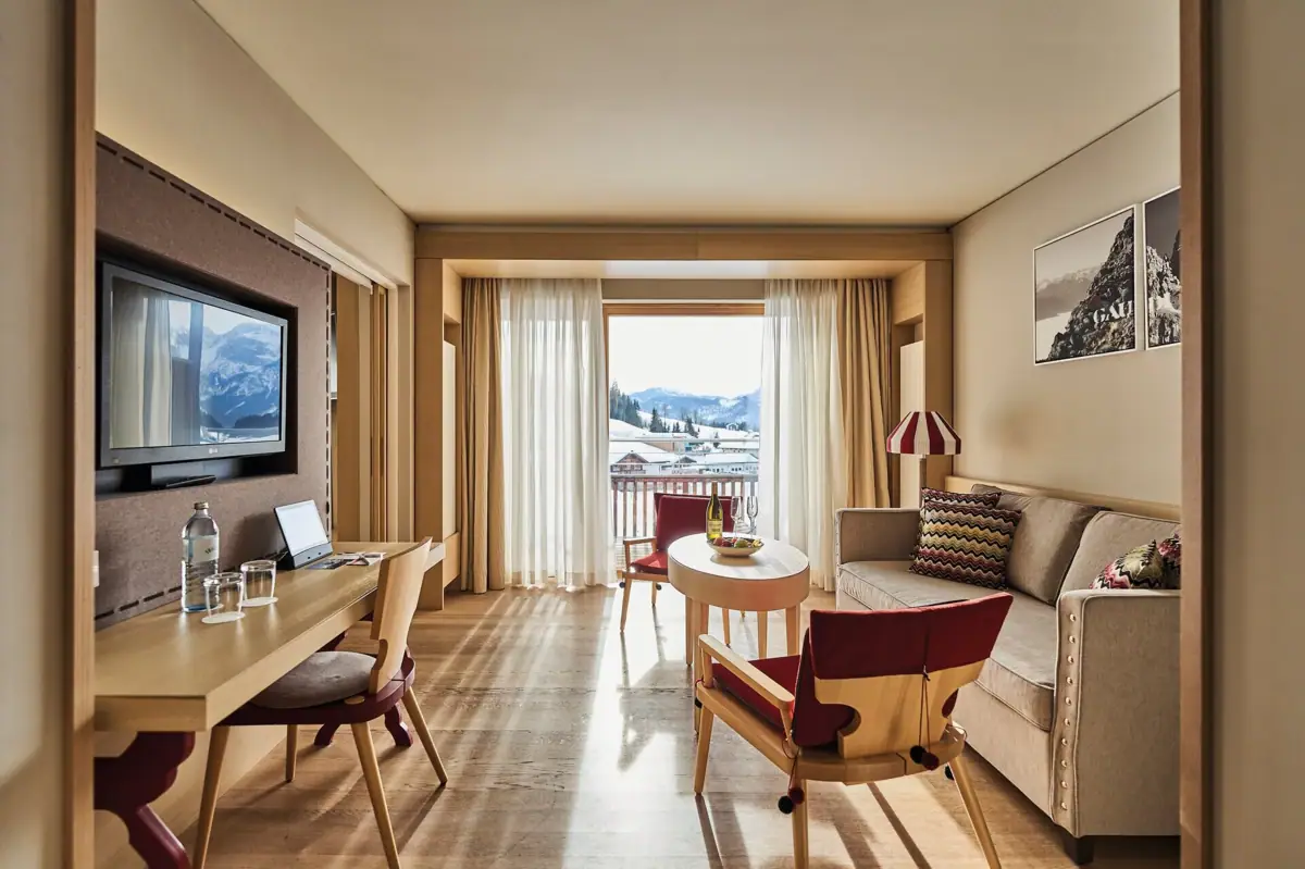 Suite Wohnzimmer Ein Raum mit einem Tisch, Stühlen und einem Fernseher.