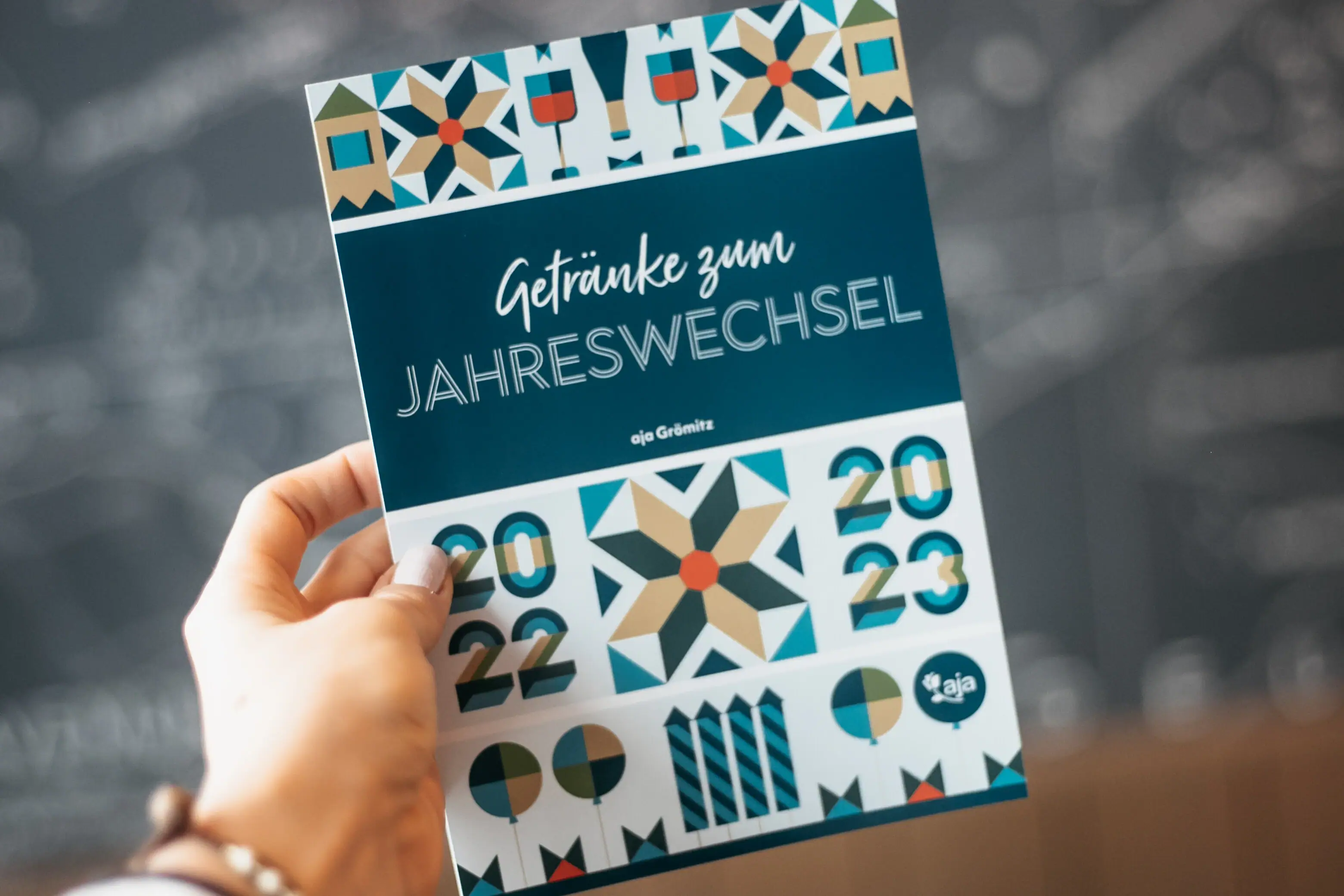 Silvester im aja Grömitz Eine Hand hält ein Programmheft der Silvesterparty.