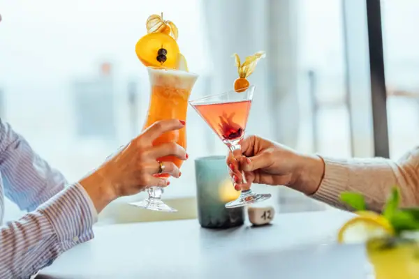 Cocktails Ein Paar Hände hält Gläser mit Getränken.