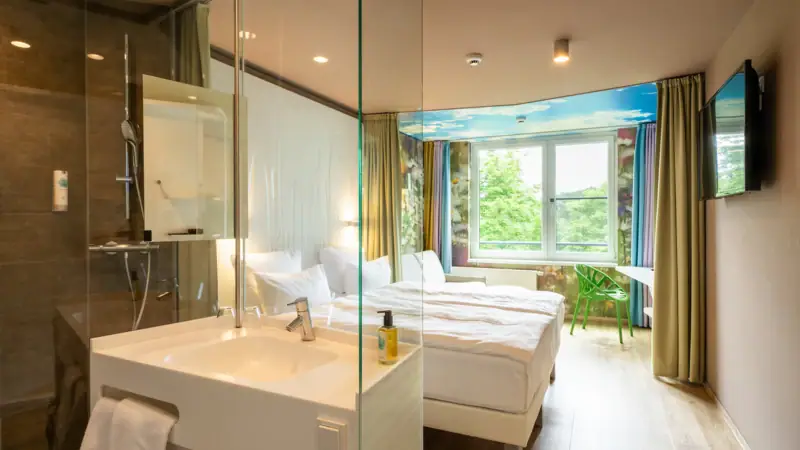 Zimmer im aja Bad Saarow Ein Raum mit einer Glasdusche und zwei Betten.