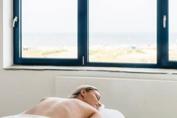 Massage Eine Frau liegt auf einem Massagetisch.